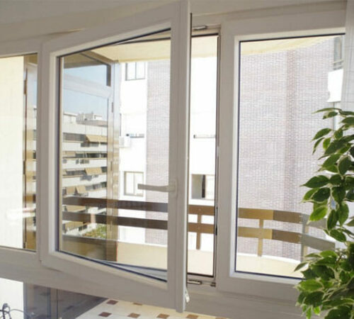 UPVC tilt and turn window opened on its side hinge in an apartment