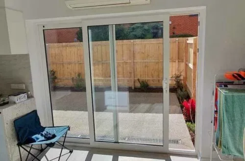 UPVC sliding door opening onto a timber-fenced courtyard
