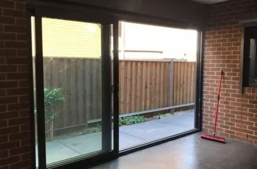 UPVC stacker door opening onto a brick-paved courtyard